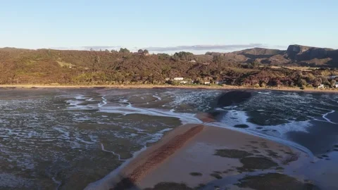 Aerial pullback over coastal estuary and hills South Island New Zealand sunset Video stock 335273690