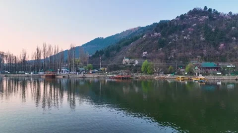 Aerial pullback over Dal Lake revealing Shikara and Shankaracharya Hill at dawn 库存影片 333791827