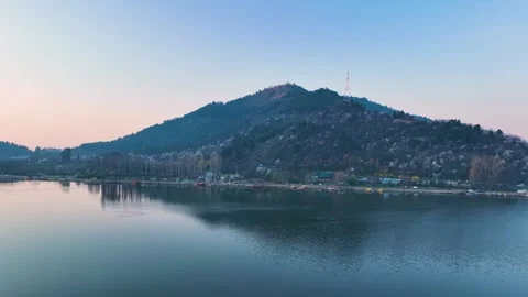 Aerial pullback over Dal Lake revealing Shankaracharya Hill at dawn 库存影片 333792157