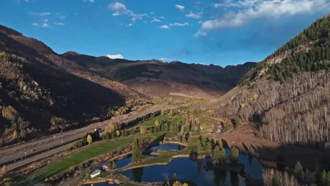 Aerial pullback over peaceful Vail valley with autumn-colored trees and Stock-Footage 293058686
