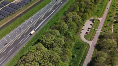 Aerial pullback reveal of Dutch solar farm with highway and wind turbines Vídeo Stock 333779953