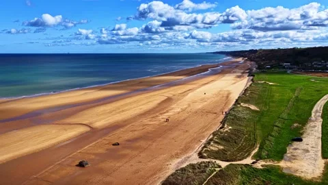 Aerial Pullback Reveal Over Omaha Beach with WWII Obstacles and Walkers Vídeos de archivo 333314301