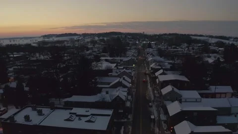 Aerial pullback reveal shot of town during sunset, sunrise. Winter snow Stock Footage 151411278