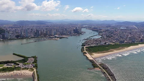 Aerial pullback revealing Itajaí harbor entrance and Navegantes coastline in Video stock 333159994