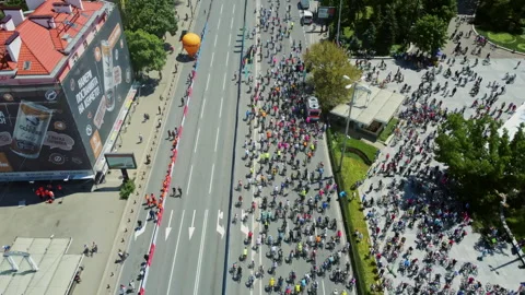Aerial pullback reveals thousands gathering for public cycling event 스톡 동영상 335161893