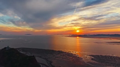 Aerial Pullback Reveals Wind Turbine Against Blazing Sunset Over Nue Island Video stock 334469031