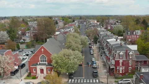 Aerial pullback reverse dolly tracks vehicle on urban city street in USA. Stock Footage 154236698