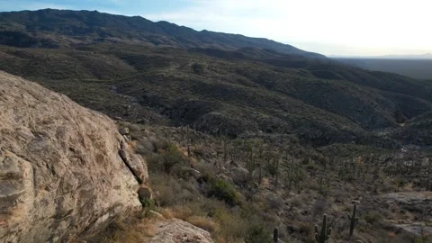 Aerial pullback of a rock outcrop and a scenic desert valley Video stock 224081579