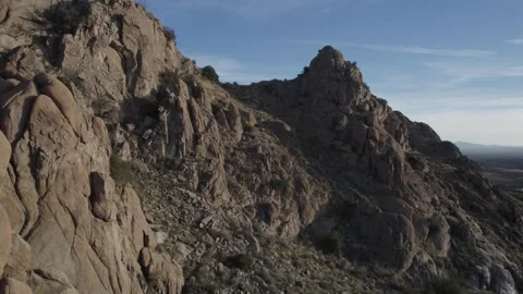 Aerial pullback of rugged granite rocks in a desert landscape Stock Footage 329769361