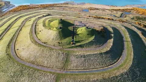Aerial Pullback from Rusting Machinery to Spiral Pathway Mound at St. Ninian's Stock Footage 273290222
