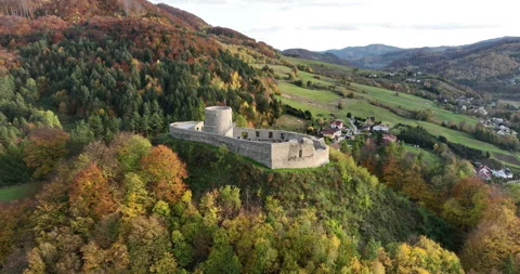 Aerial pullback from Rytro Castle ruins over autumn hills in Poland Stock Footage 346659256