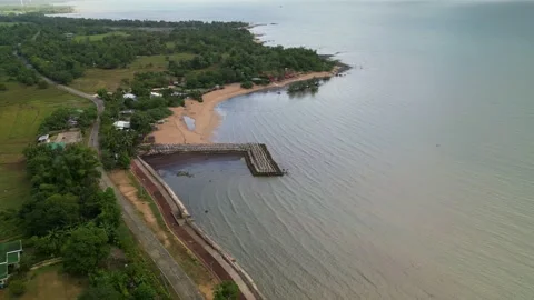 Aerial Pullback of Seaside Village and Breakwater in Guimaras, Philippines Stock Footage 332378956
