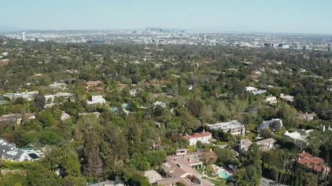 Aerial pullback shot of Beverly Hills residence homes and Los Angeles skyline Stock Footage 272517517