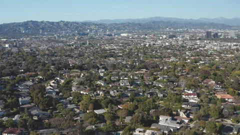 Aerial pullback shot of Beverly Hills residences and commercial building skyline Stock Footage 272685190