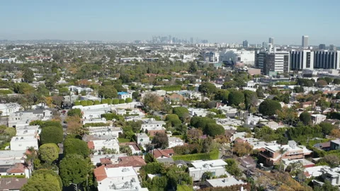 Aerial pullback shot of Beverly Hills residential community and LA skyline Stock Footage 272702763
