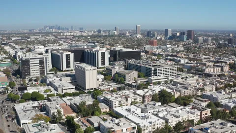 Aerial pullback shot of Beverly Hills shops, homes, apartments, and LA skyline Stock Footage 272759325