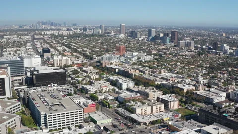 Aerial pullback shot of Beverly Hills downtown center and Los Angeles skyline Stock Footage 273757799