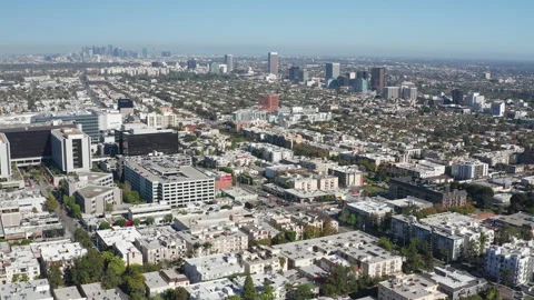 Aerial pullback shot of Beverly Hills office buildings, shops, homes and skyline Stock Footage 273757823