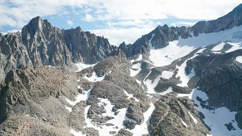Aerial pullback shot of Eastern Sierra mountain peaks, glacier, alpine lake Stock Footage 122861690