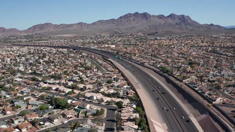 Aerial pullback shot of Henderson Nevada with mountains in background and cars Stock Footage 271276351