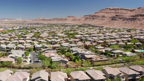 Aerial pullback shot of Las Vegas residential homes with sandstone mountains Stock Footage 200859336