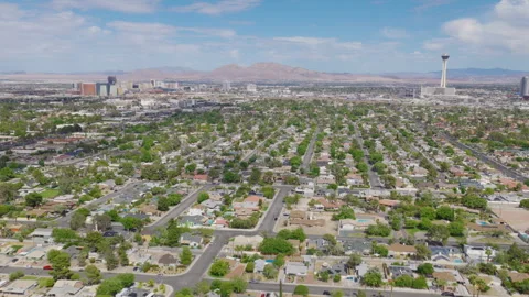 Aerial pullback shot of Las Vegas homes and downtown skyline and mountains Video stock 333484365