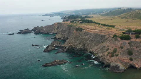 Aerial pullback shot of Pacific Ocean cliffs and waves in northern California Stock Footage 200776641