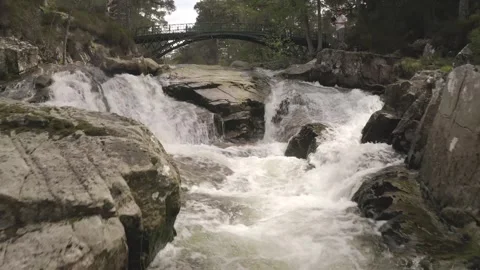 Aerial pullback shot of river and Garbh Allt Falls Bridge in Ballochbuie Forest Vídeos de archivo 251050635