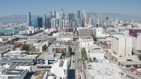 Aerial pullback shot of urban Los Angeles downtown and freeway car traffic Stock Footage 273750406