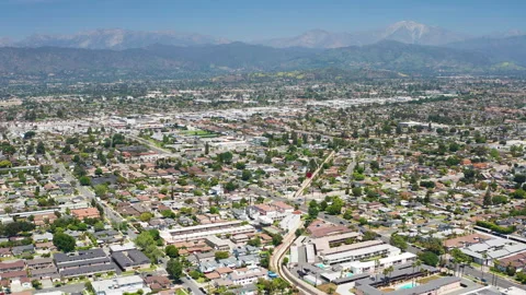 Aerial pullback shot of West Covina Los Angeles California County homes mountain Stock Footage 308031937