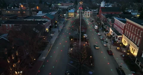 Aerial pullback of small town at night. Lights for Christmas decorate for Stock Footage 168350396