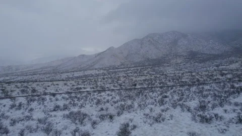 Aerial pullback of snow covered mountains in the Arizona desert Stock Footage 234551174
