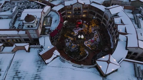 Aerial Pullback From Snow-Covered Outlet Mall Courtyard to Wide View Stock Footage 344925651