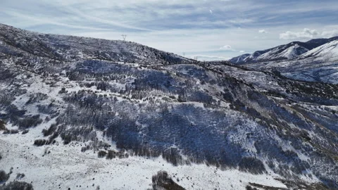Aerial-Pullback-Snowy hills-electrical power tower on skyline Stock Footage 267045913