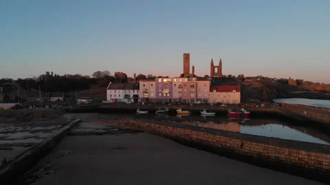 Aerial pullback from St Andrews harbour to pier at sunrise Stock Footage 147600783
