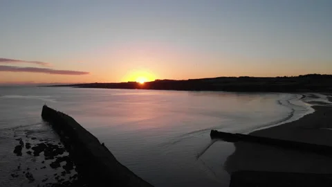 Aerial pullback as sun crests horizon during sunrise Stock Footage 147599928
