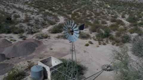 Aerial pullback of a traditional ranch windmill pumping water Stock Footage 254357618