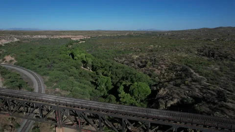 Aerial pullback of a train trestle and arched highway bridge infrastructure Stock Footage 195199470