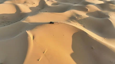 Aerial pullback from a vehicle on a dune crest to a desert panorama Video stock 347846272