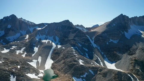 Aerial pullback view of alpine lakes, glaciers, mountain peaks in Eastern Sierra Stock Footage 122847639