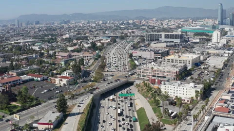 Aerial pullback view of busy freeway highway traffic and parking garages Stock Footage 273754284
