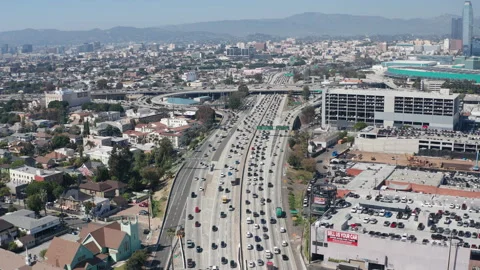 Aerial pullback view of busy freeway highway traffic and cars and garages Stock Footage 273754738