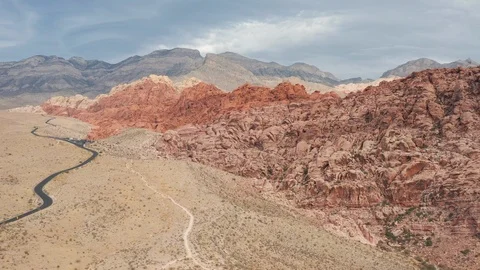 Aerial pullback view of colorful Red Rock Canyon sandstone cliffs and mountains Stock Footage 121529005