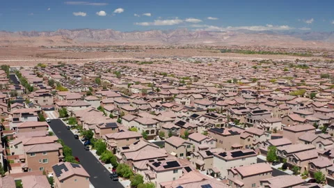 Aerial pullback view of Las Vegas suburban desert homes with Red Rock Canyon Stock Footage 308819562