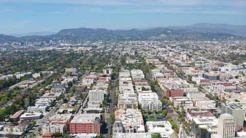 Aerial pullback view of Los Angeles buildings, Hollywood sign, homes and hills Stock Footage 308102444