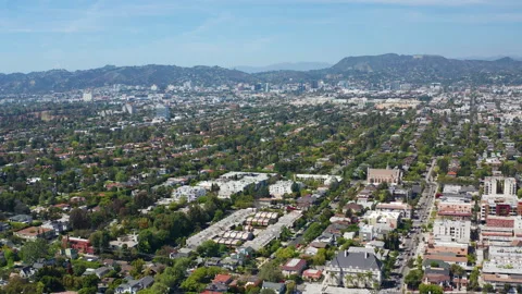 Aerial pullback view of Los Angeles homes, Hollywood hills, buildings, trees Stock Footage 308106359