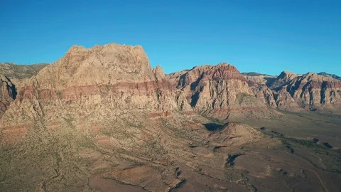Aerial pullback view of Red Rock Canyon Mountains, Wilson, Rainbow, and Bridge Stock Footage 122908466