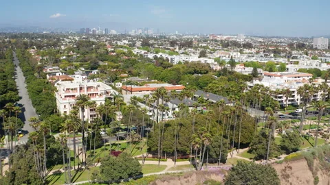 Aerial pullback view of Santa Monica Los Angeles suburb homes  tree skyline roof Stock Footage 308131070