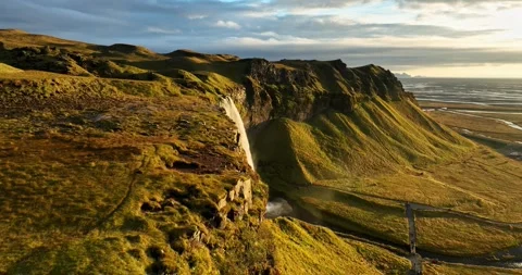 Aerial pullback view of Seljalandsfoss in Iceland, revealing dramatic cliff Stock-Footage 333642549