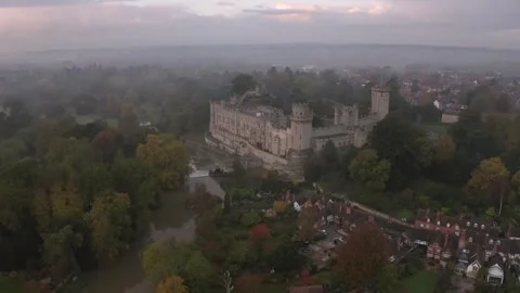 Aerial pullback view of Warwick Castle at River Avon with town in mist autumn Vídeos de archivo 251039002